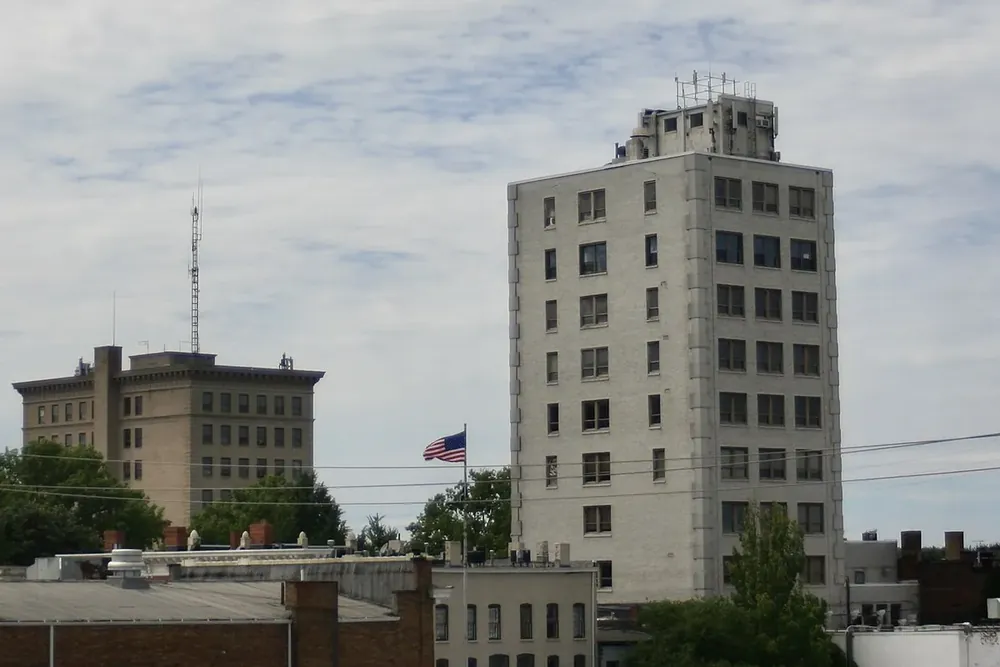 Downtown Elyria's historic high-rise buildings above the treetops under a cloudy sky, Ohio