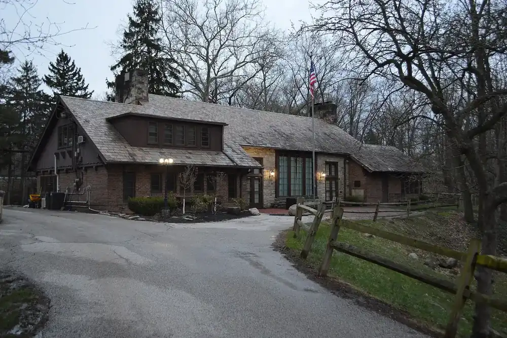 Stone and timber Bain Park Cabin beside a wooded drive in Fairview Park, Ohio