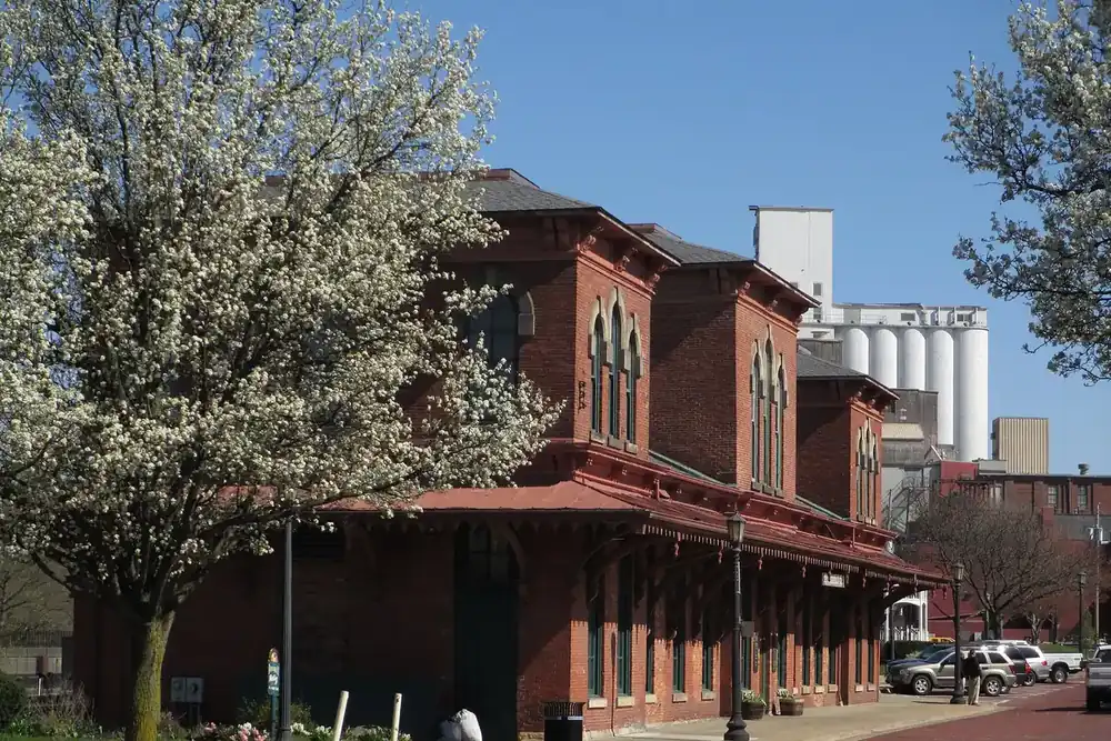 Historic brick rail depot under blossoming trees in downtown Kent, Ohio