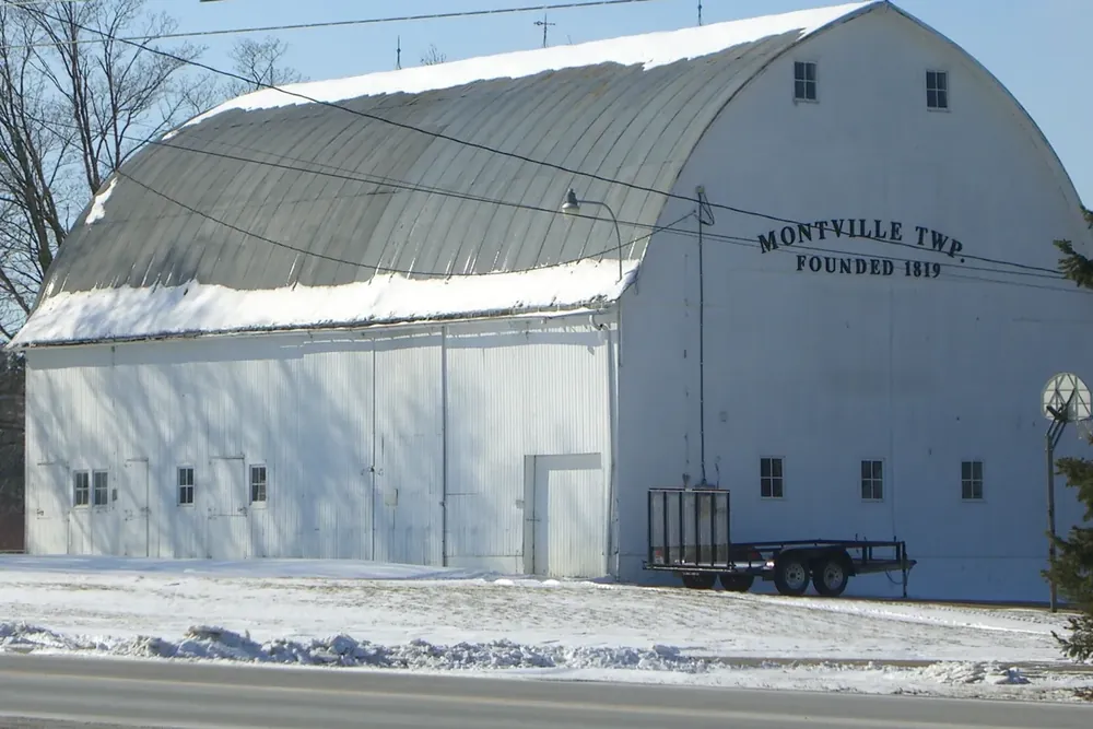 Large white township barn with a curved roof along State Route 57 in Montville Township, Ohio