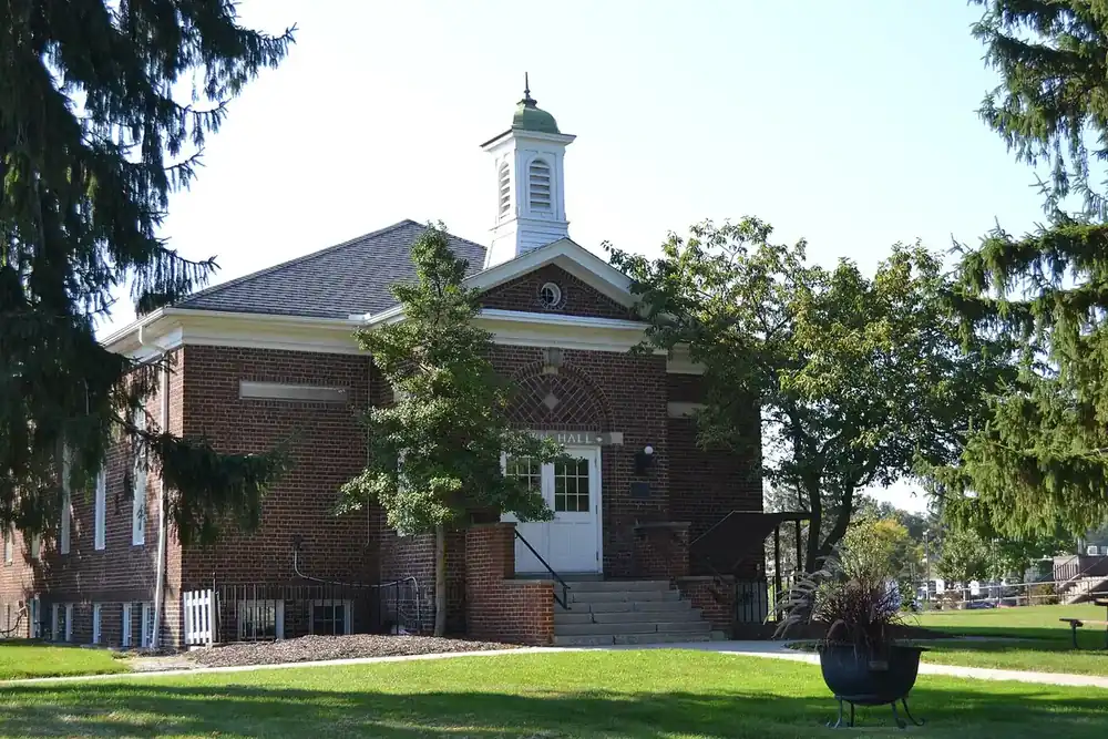 Brick Old Town Hall with a white cupola among shade trees in North Olmsted, Ohio